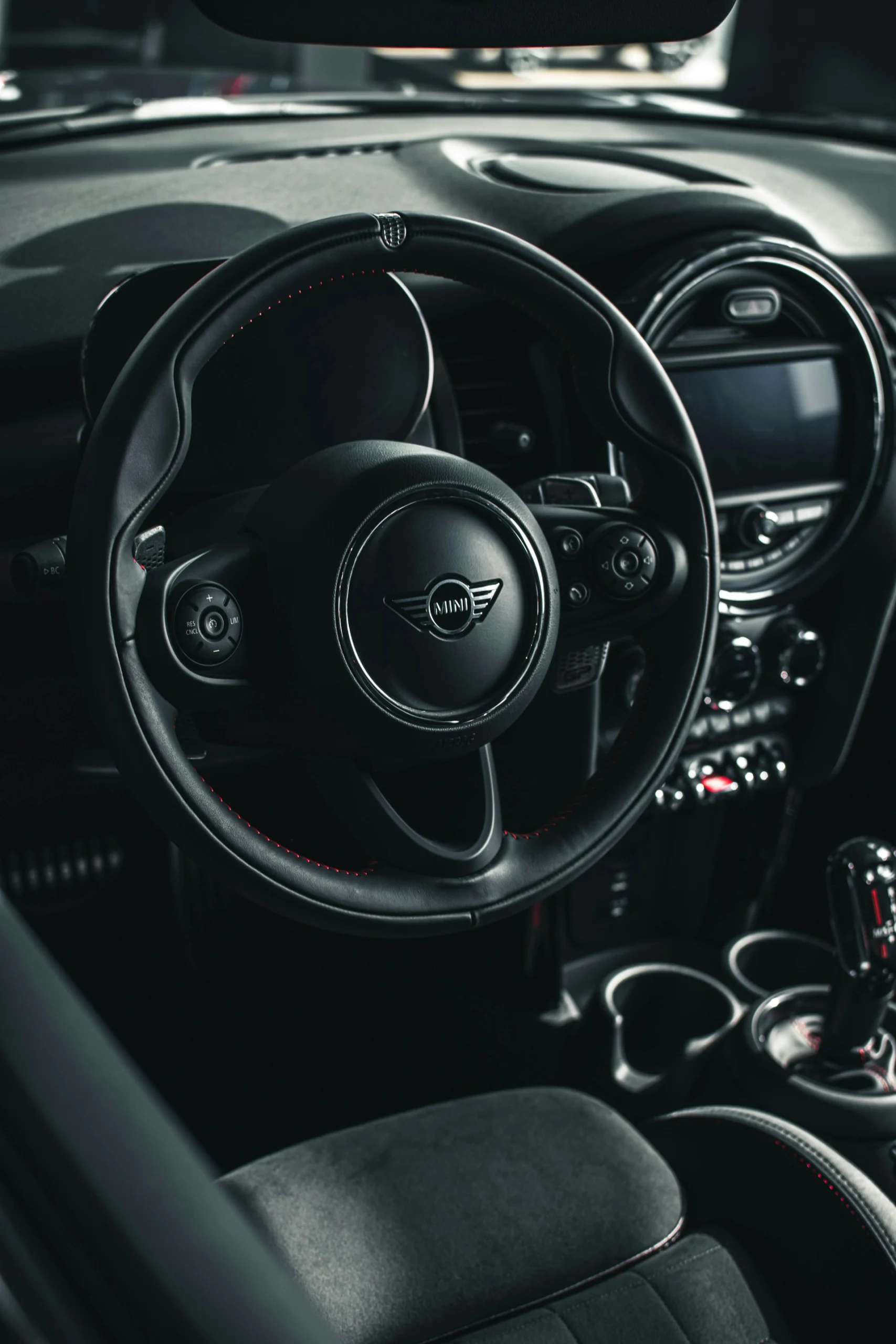 MINI vehicle interior showing steering wheel, center display, and dashboard controls