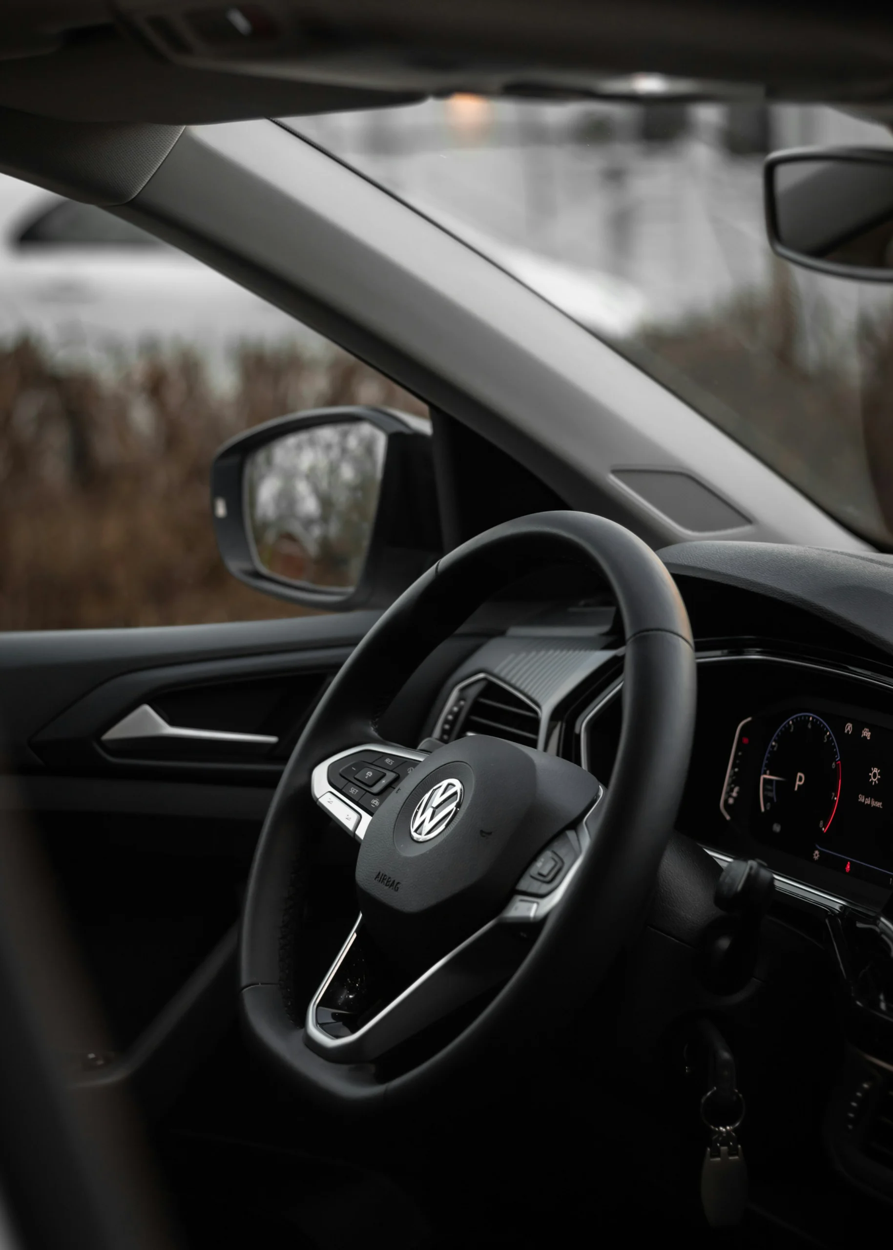 Volkswagen interior showing steering wheel, dashboard controls, and digital instrument display